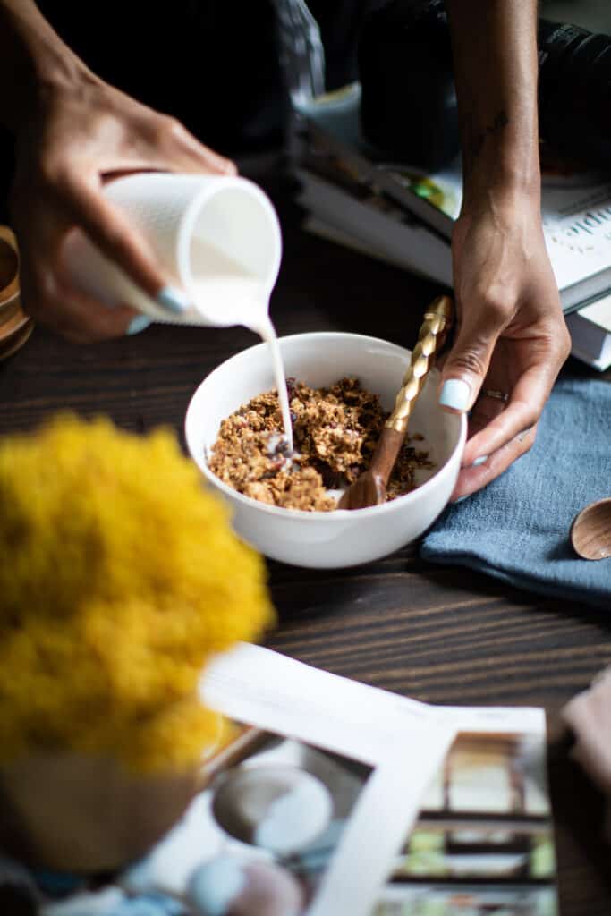 Woman pouring milk into a bowl.