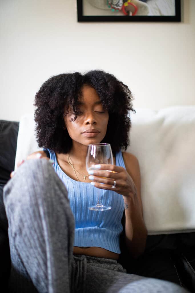 Shanika wearing a blue shirt and holding a wine glass.