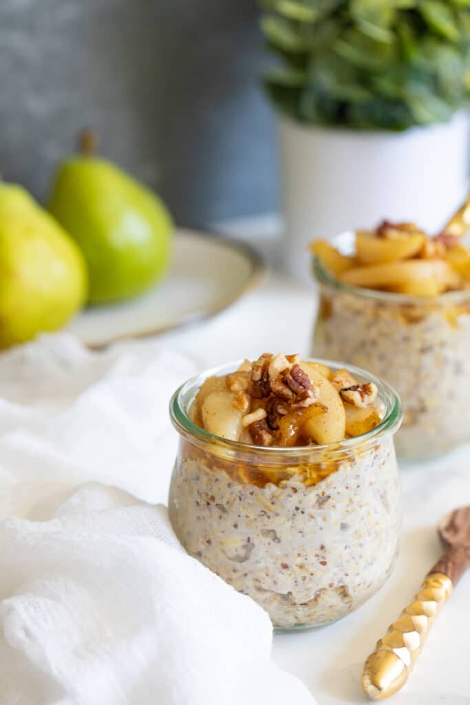 Vanilla Overnight Oats with Maple Spiced Pears in two small glasses.