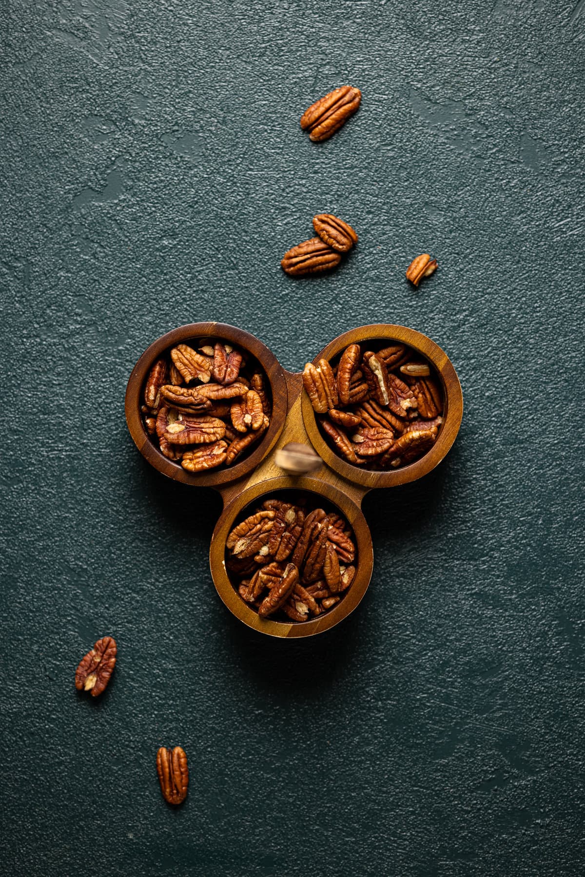 Pecans in three small, wooden bowls