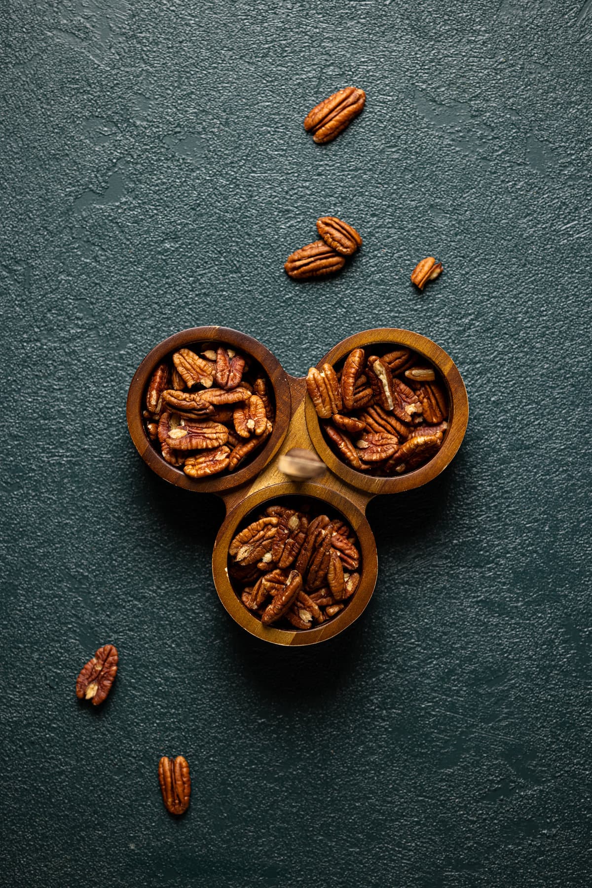 Pecans in three small, wooden bowls