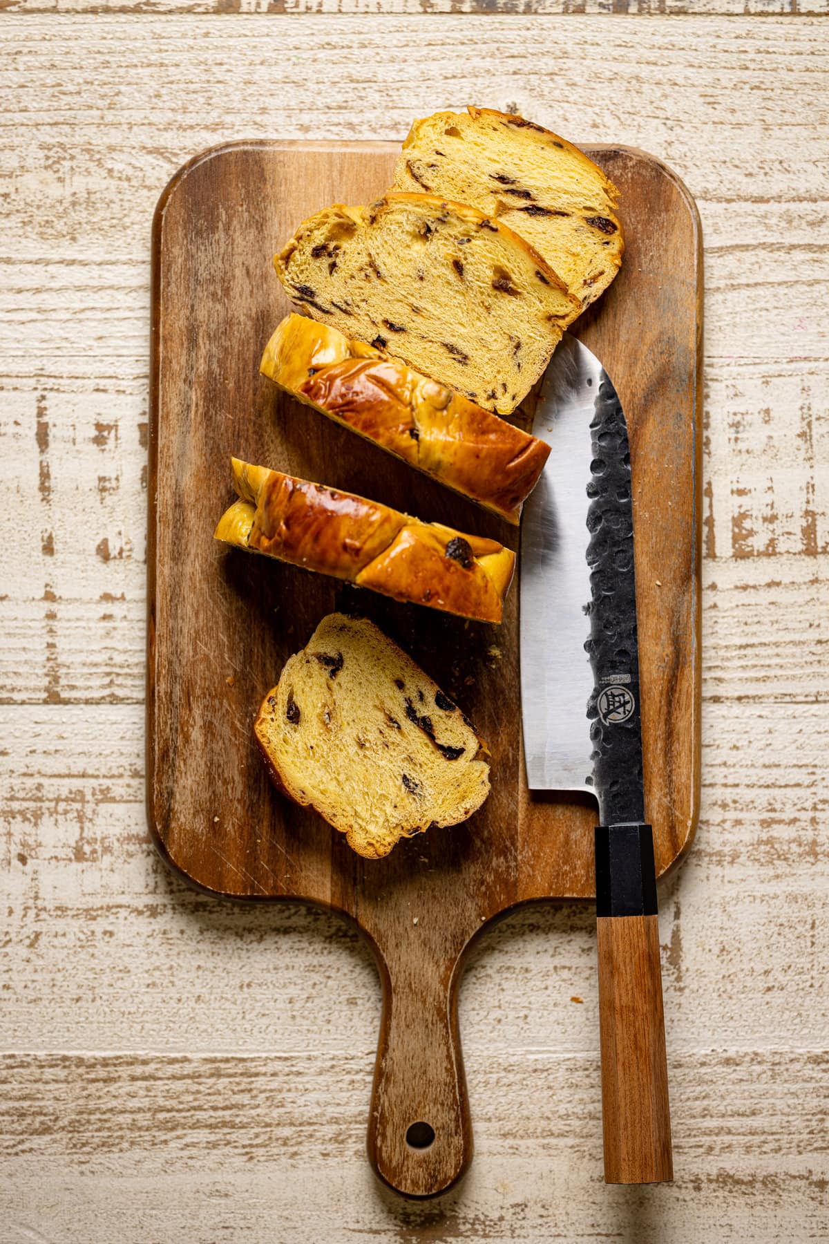 Sliced brioche on a cutting board with a knife