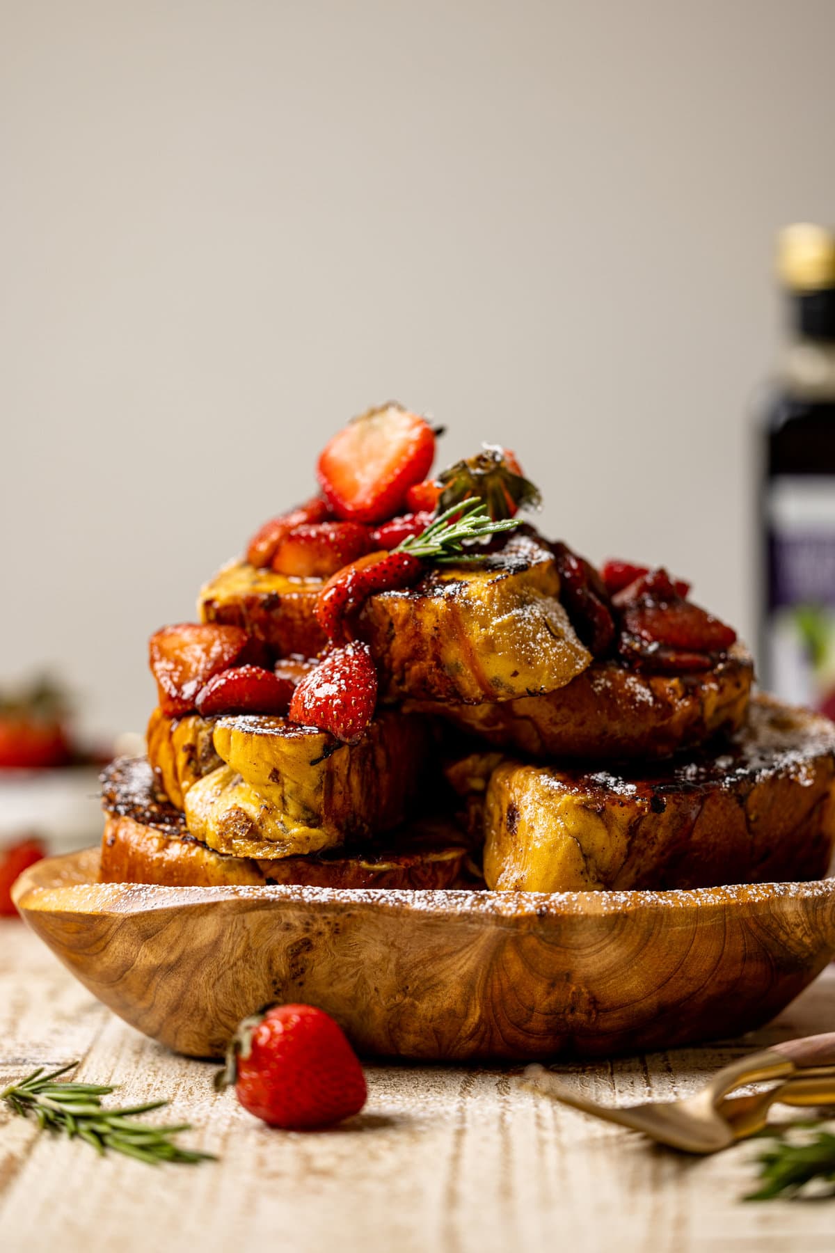 Wooden plate piled with Balsamic Strawberry Brioche French Toast