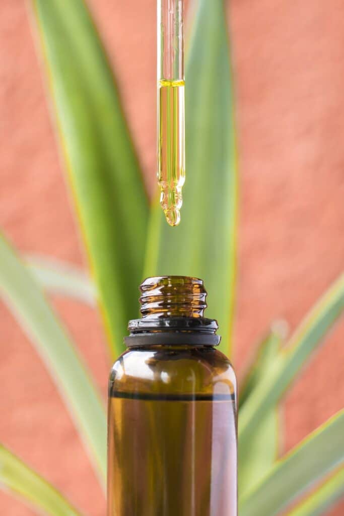 Dropper above a bottle of essential oil.