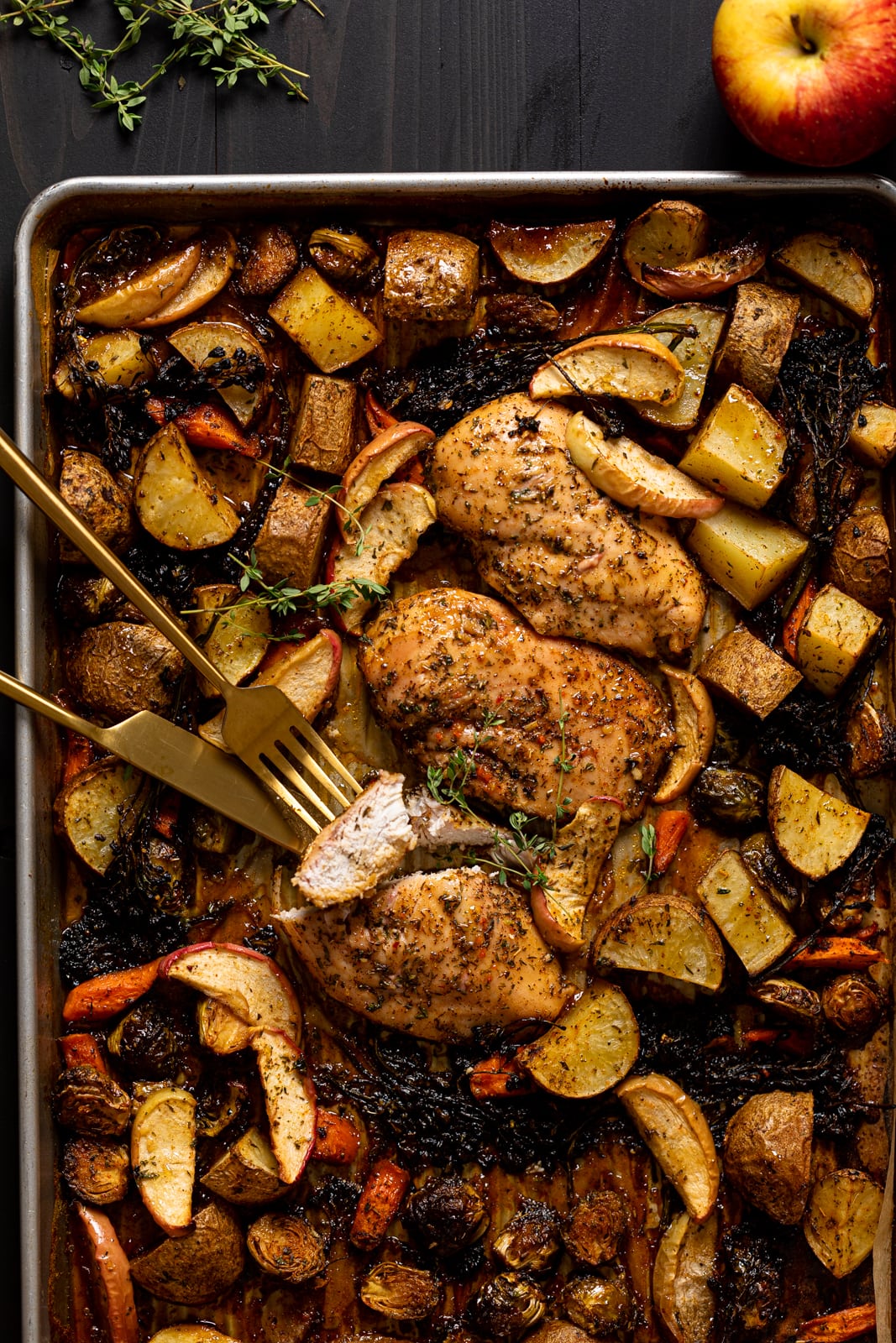 Maple Apple Chicken and Veggies on a sheet pan with gold silverware.