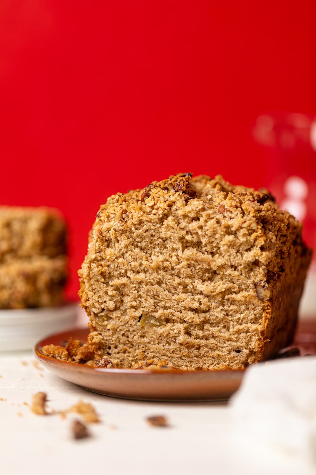 Vegan Apple Bread with one end sliced off on a brown plate.