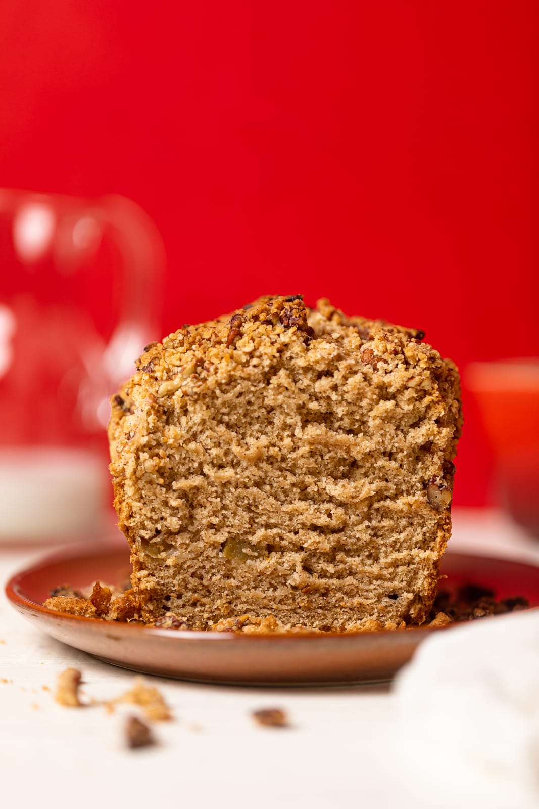 Vegan Apple Bread with one end sliced off on a brown plate.