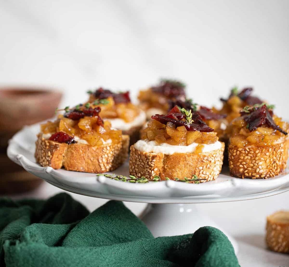 Several Fall Harvest Apple Bacon Crostini on an elevated serving dish