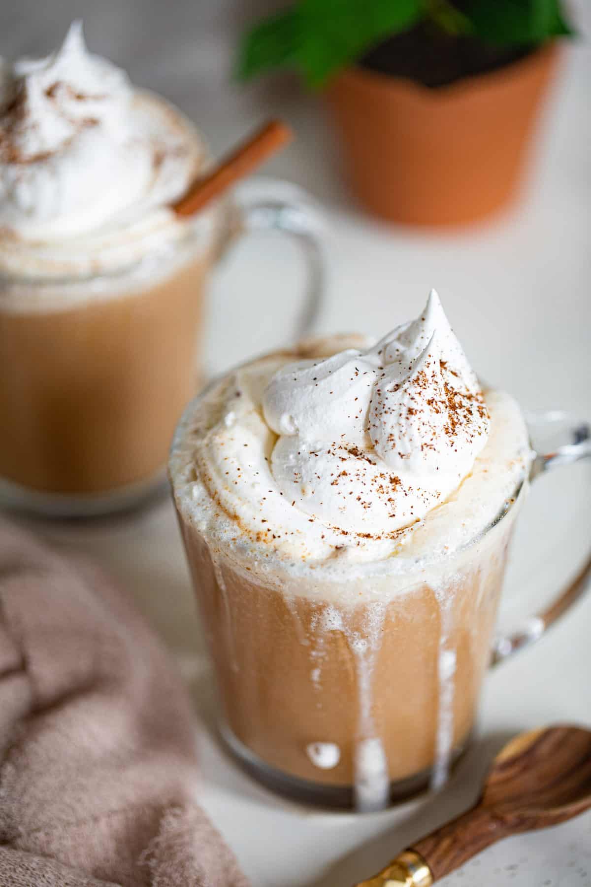 Warm Apple Chai Latte topped with whipped cream.