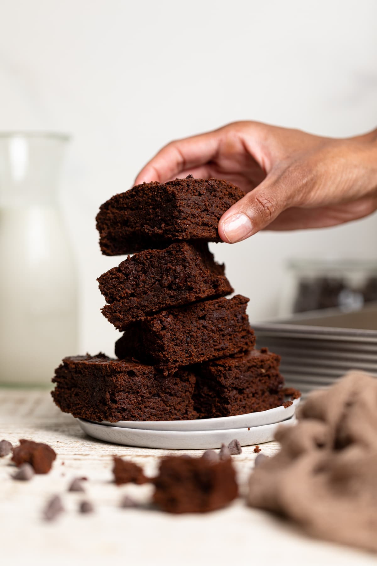 Woman grabbing from a Fudgy Vegan Brownie Stack.