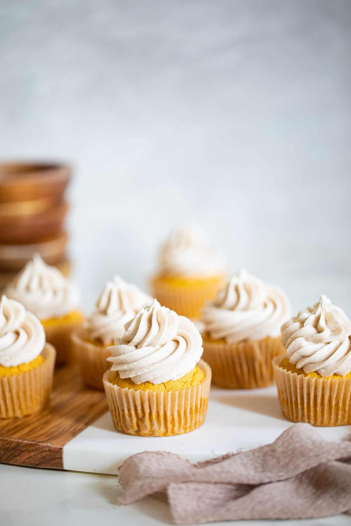 Pumpkin Chai Cupcakes on a wooden board.
