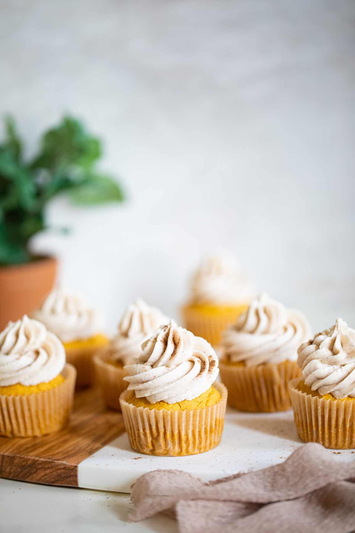 Wooden board topped with Pumpkin Chai Cupcakes.