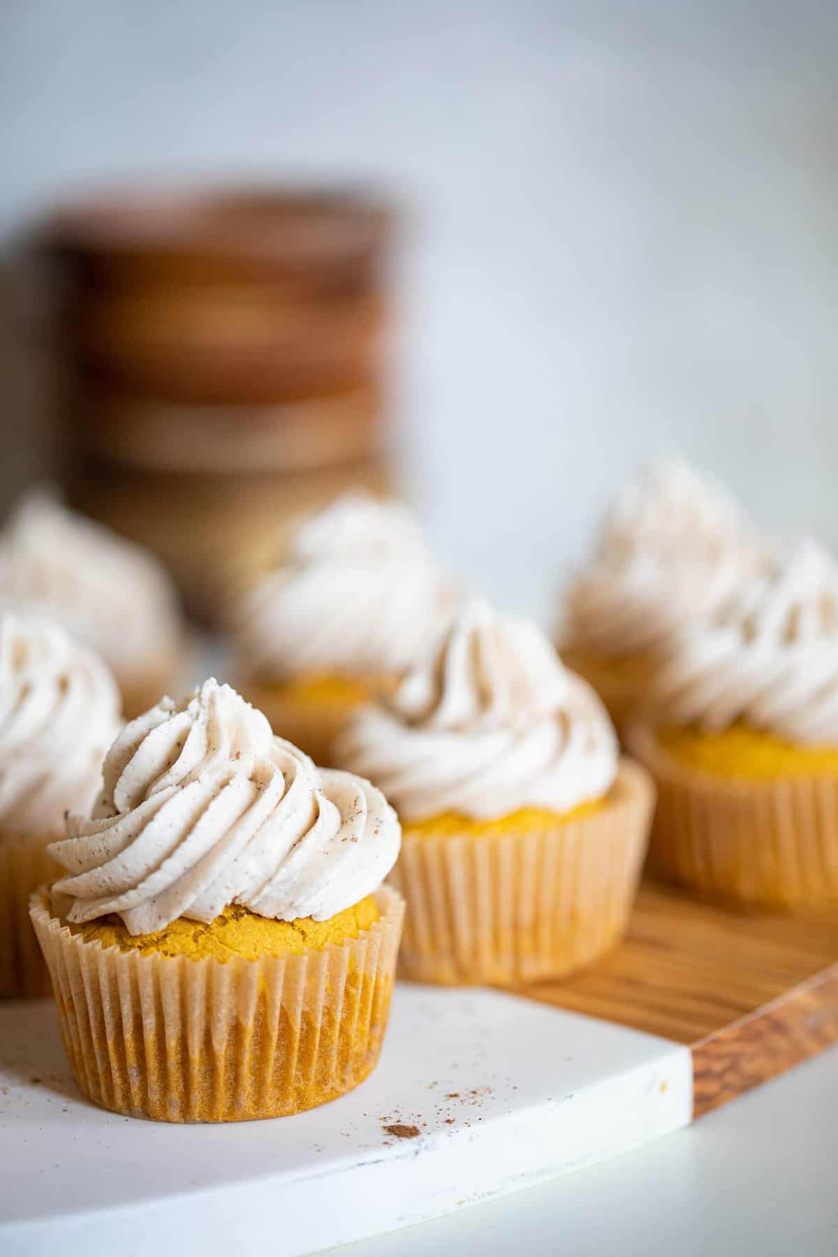 Wooden board topped with Pumpkin Chai Cupcakes.