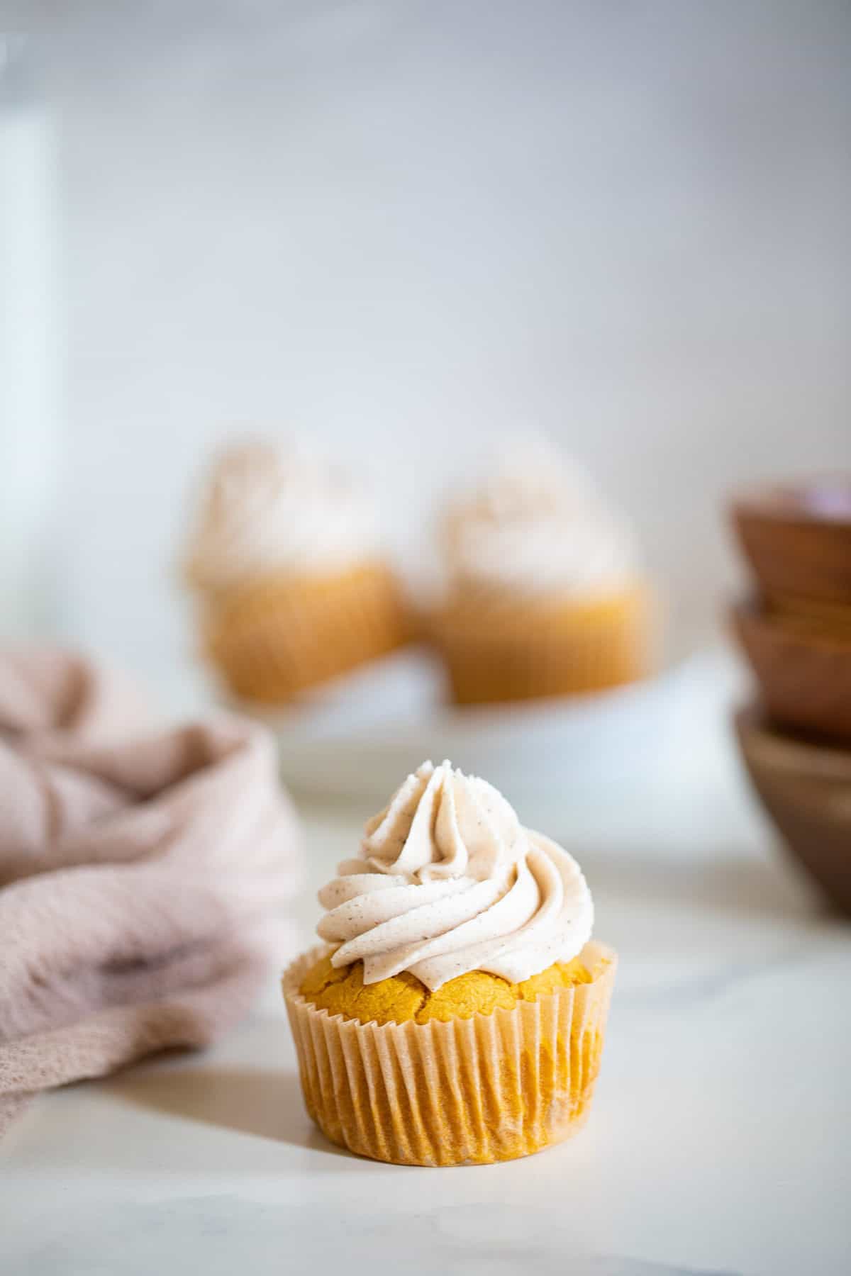 Pumpkin Chai Cupcake on a marble countertop.