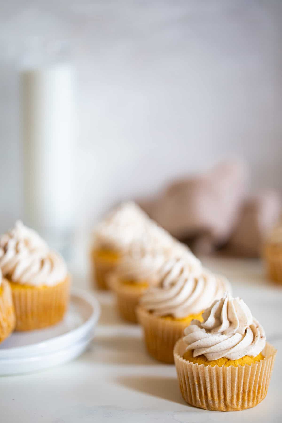 Line of Pumpkin Chai Cupcakes on a countertop.