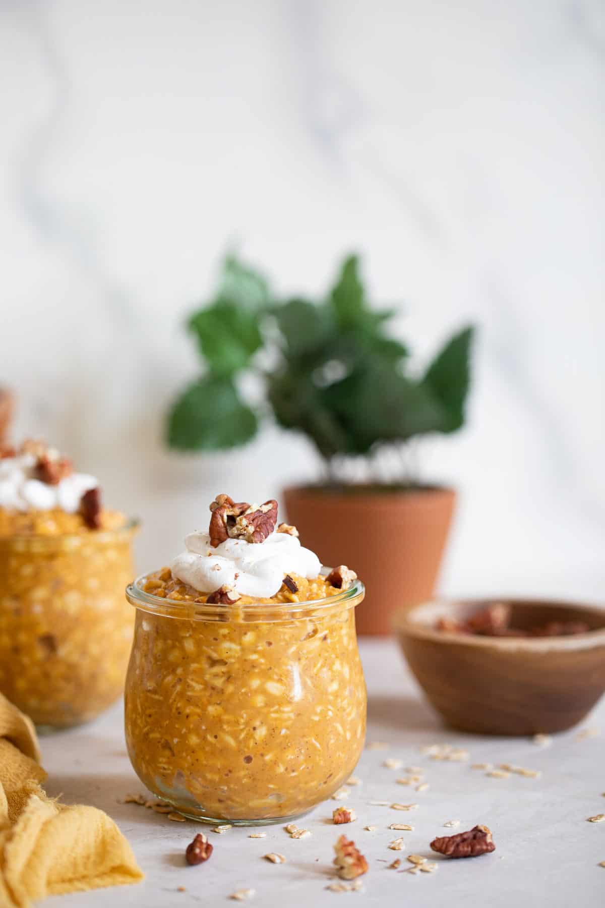 Pumpkin Spice Overnight Oats topped with whipped cream and nuts.