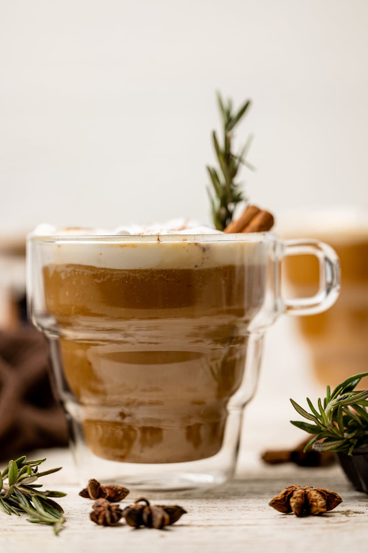 Glass mug of Vegan Pumpkin Chai Latte with a cinnamon stick.