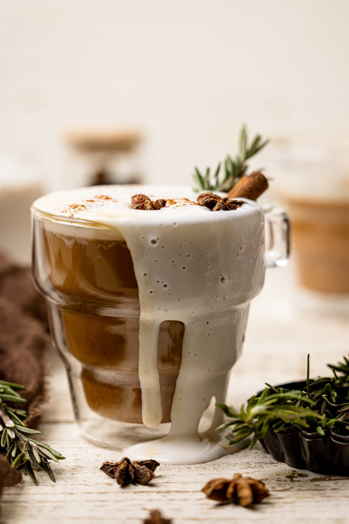 Glass mug overflowing with Vegan Pumpkin Chai Latte.