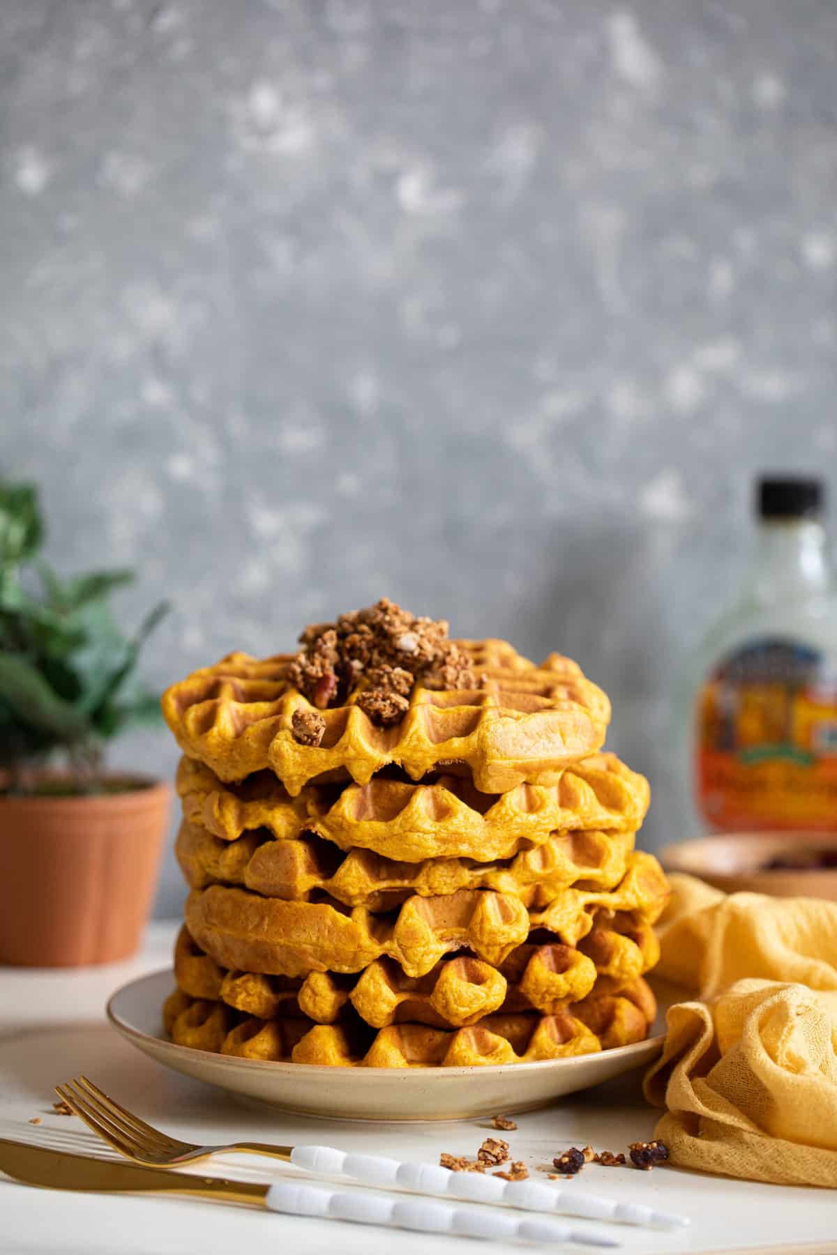 Stack of Vegan Pumpkin Spice Waffles topped with granola.