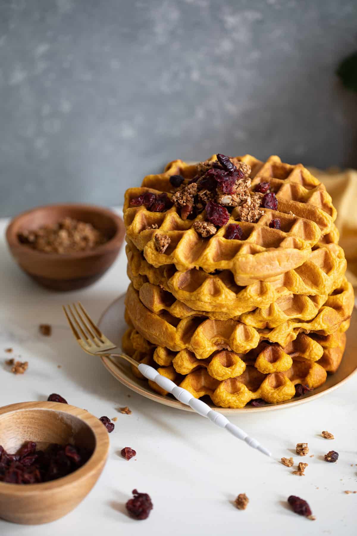 Stack of Vegan Pumpkin Spice Waffles topped with granola.