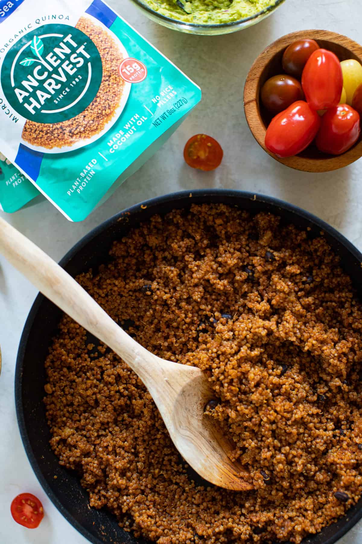 Wooden spoon in a bowl of Black Bean and Quinoa Nacho topping.