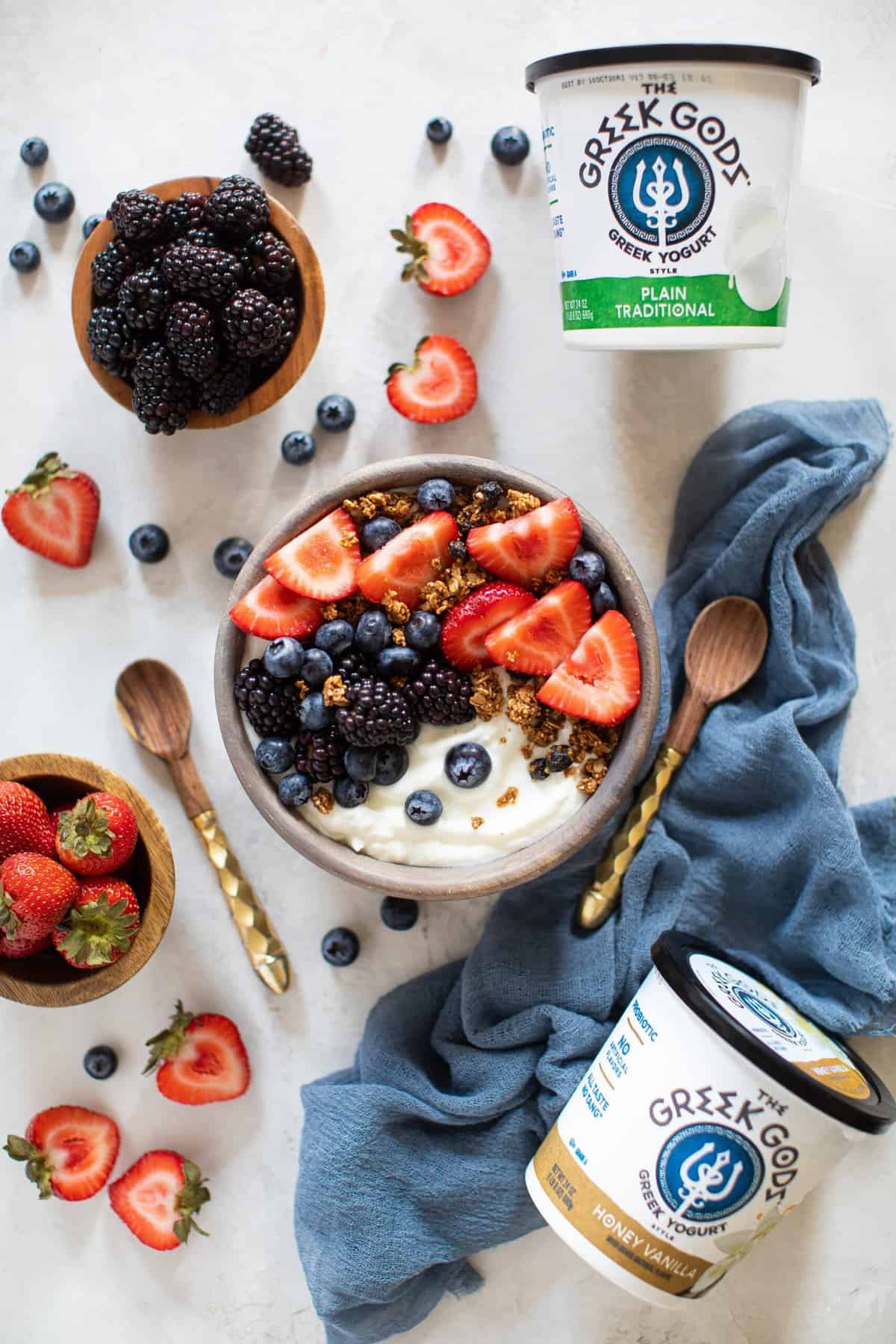 Greek Yogurt Breakfast Bowl on a table with fruit and Greek Gods yogurt.