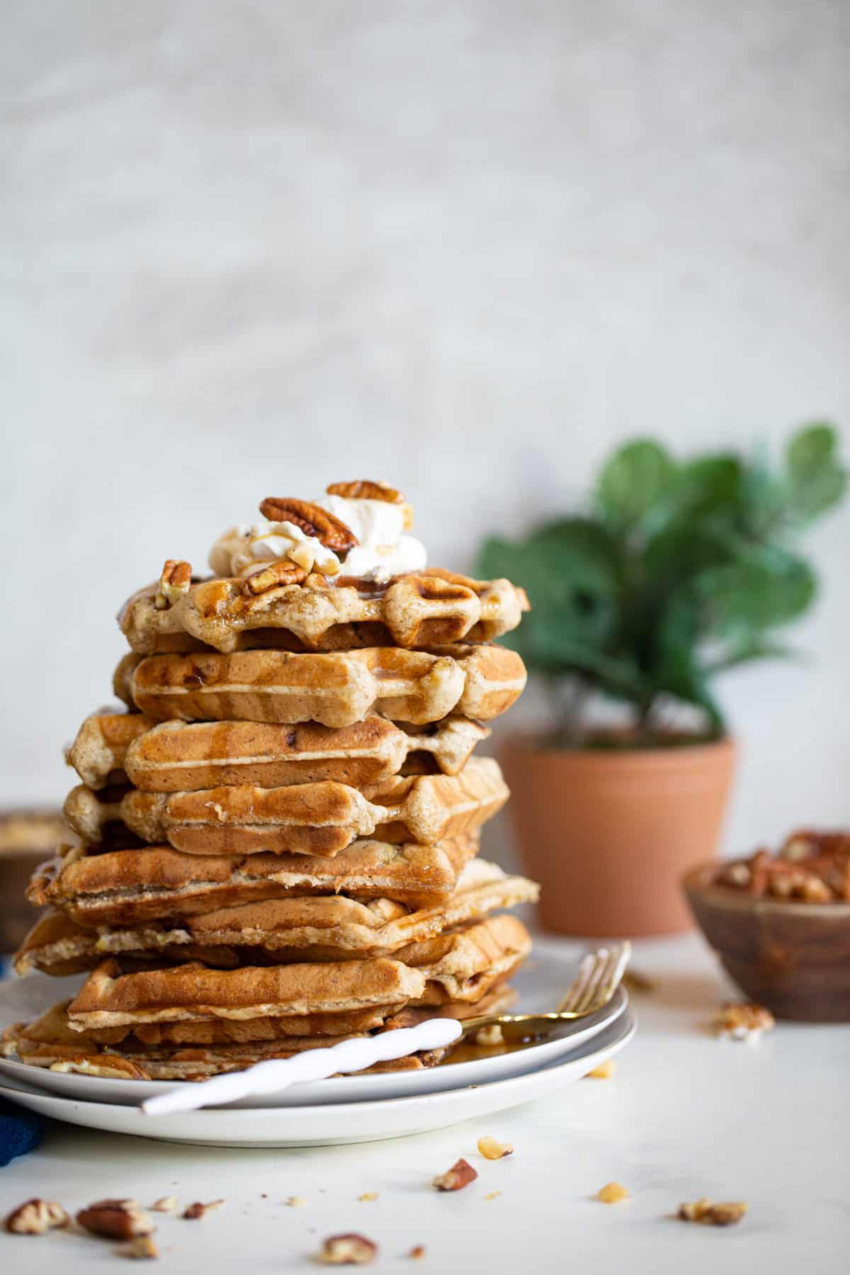 Stack of Maple Brown Butter Banana Waffles on a plate with a fork.