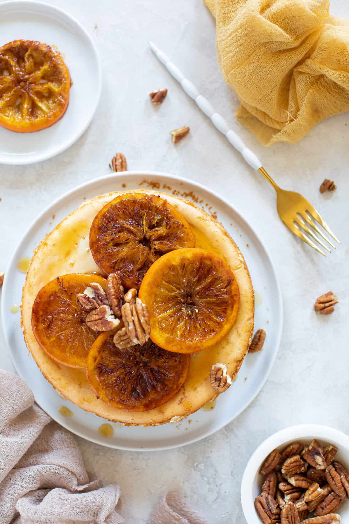 Spiced Orange Cheesecake with Pecan Crust on a plate next to a fork.