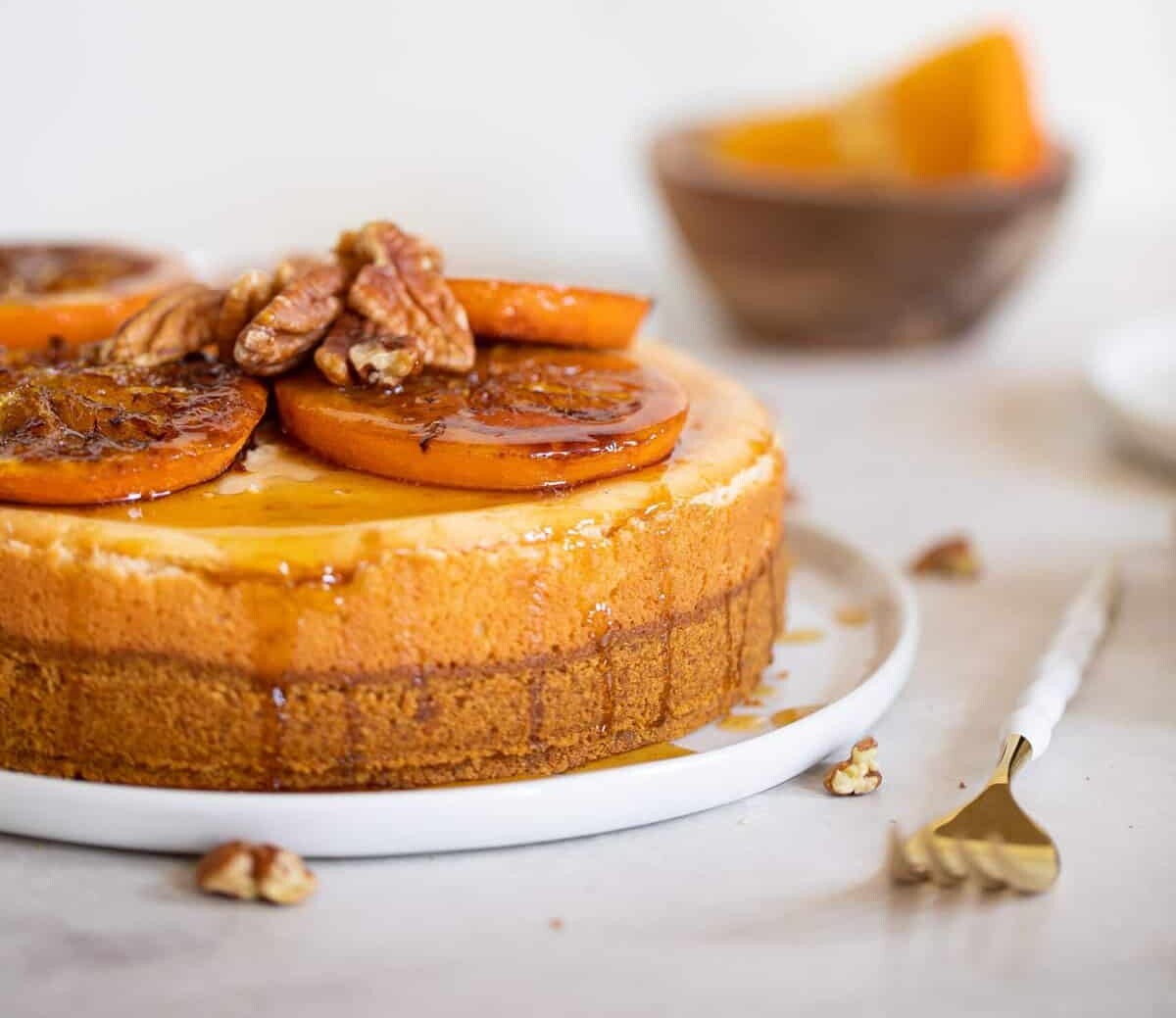 Spiced Orange Cheesecake with Pecan Crust topped with sliced oranges.