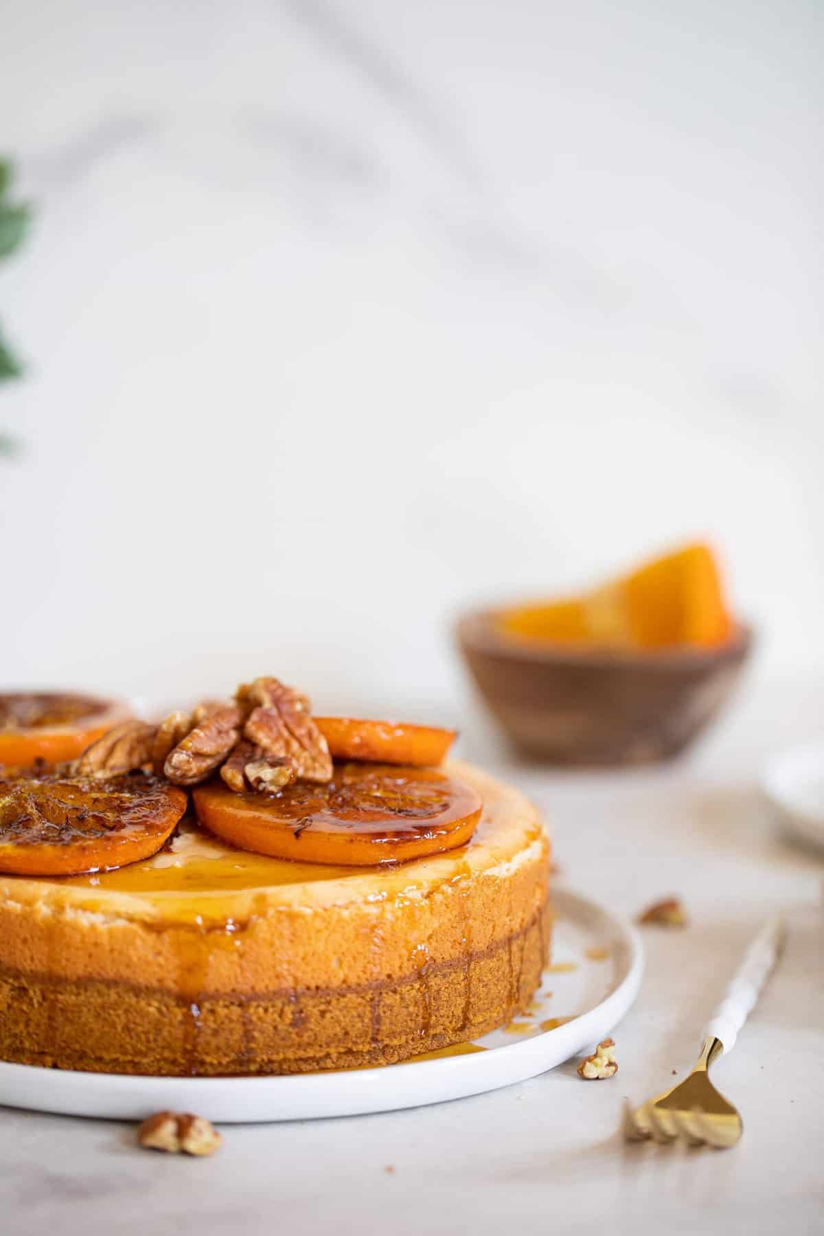 Spiced Orange Cheesecake with Pecan Crust topped with sliced oranges.