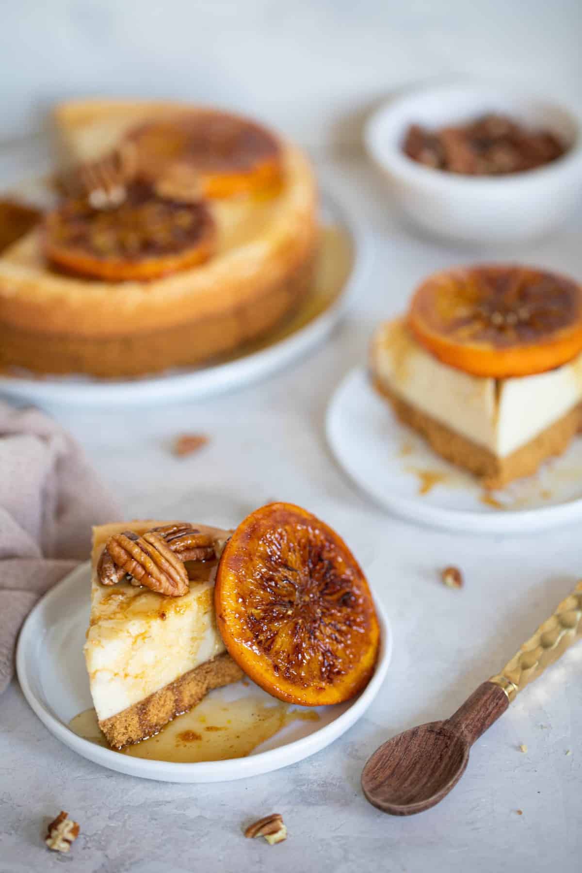 Slices of Spiced Orange Cheesecake with Pecan Crust on small plates.