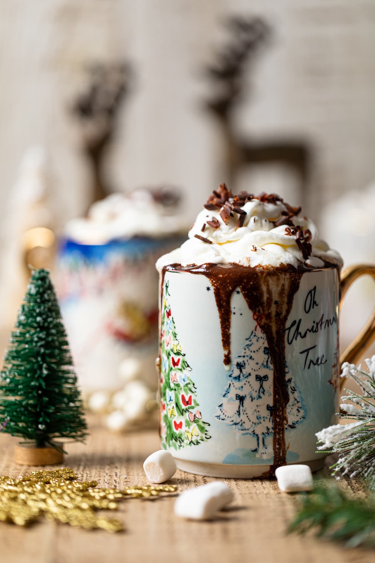 Mug of Creamy Caramel Hot Chocolate on a table with Christmas decorations