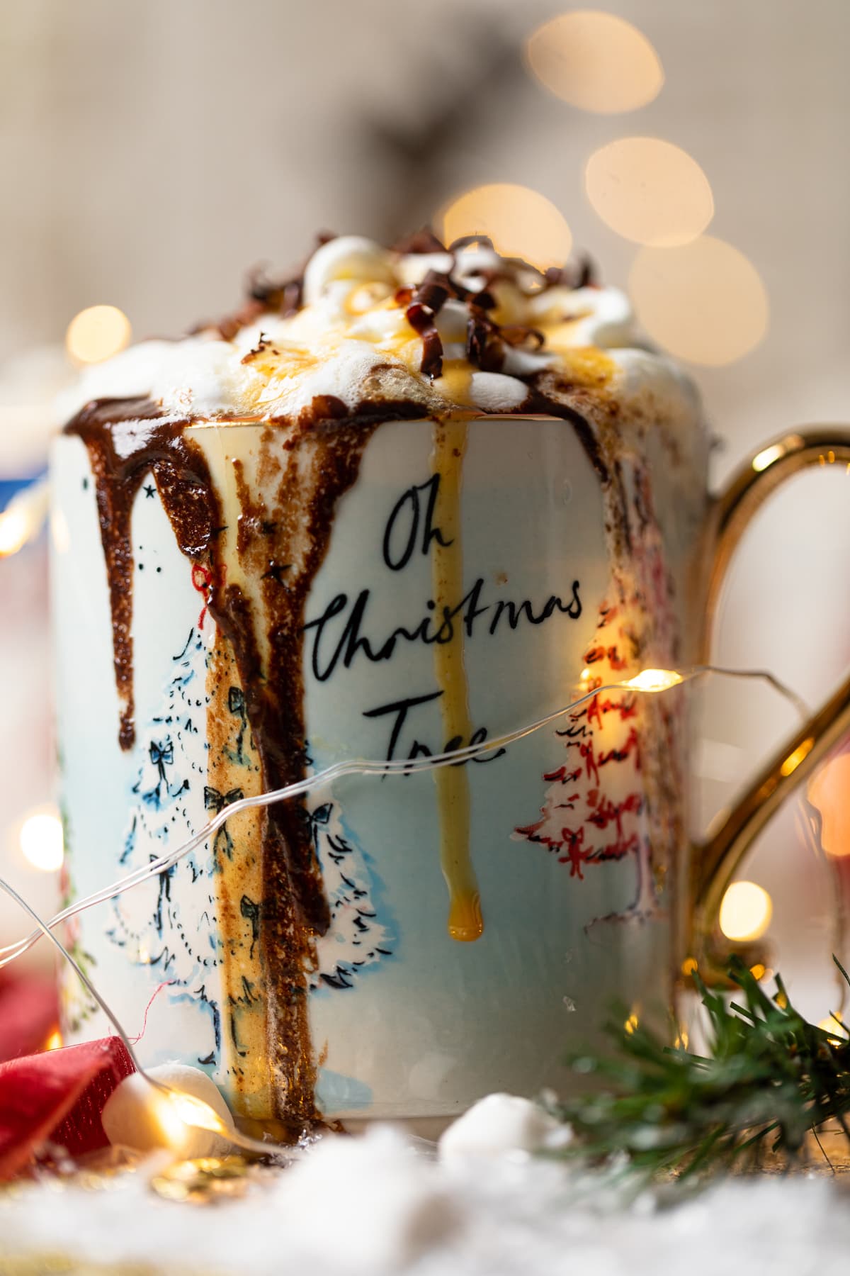 Caramel and chocolate dripping down the sides of a mug of Creamy Caramel Hot Chocolate