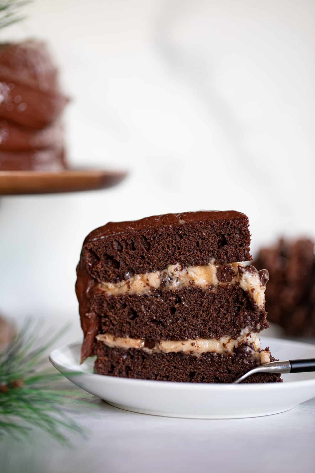 Slice of Vegan Brownie Cookie Dough Cake on a plate with a fork.