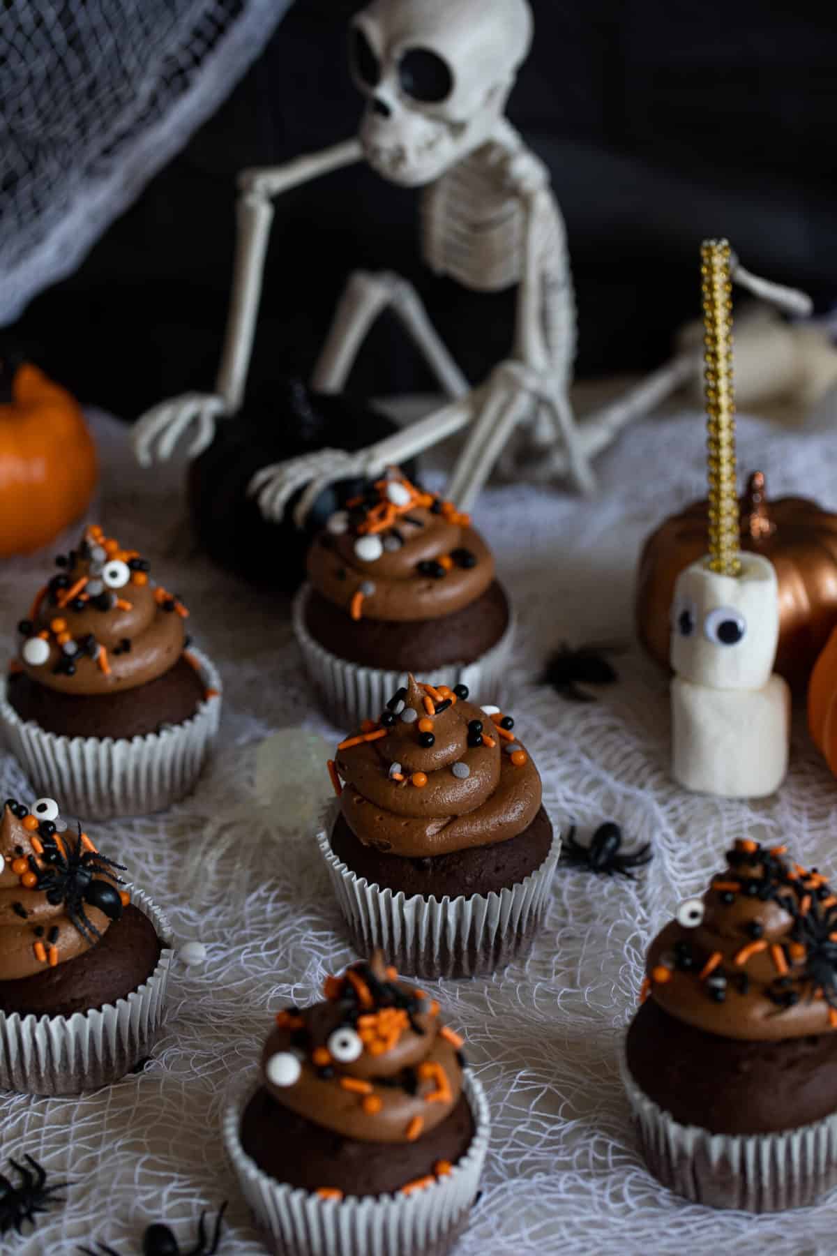 Spooky Double Chocolate Cupcakes on a table with Halloween decorations.