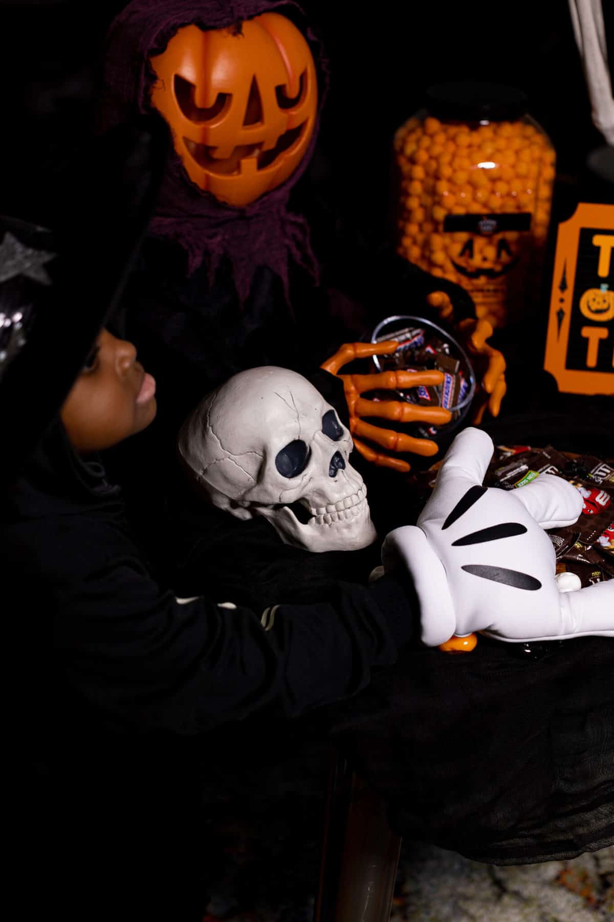 Child with his arms around a decorative skull.