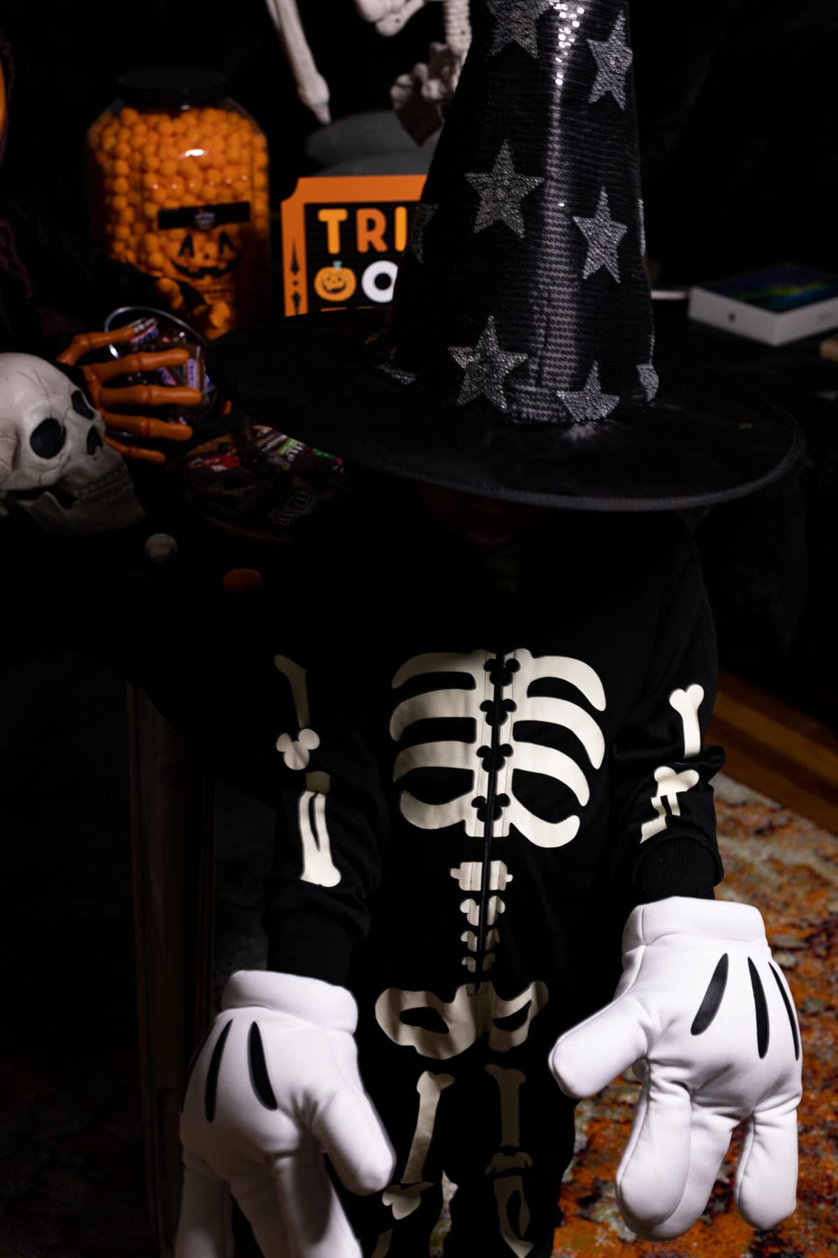 Child dressed as a skeleton with a large witch hat.