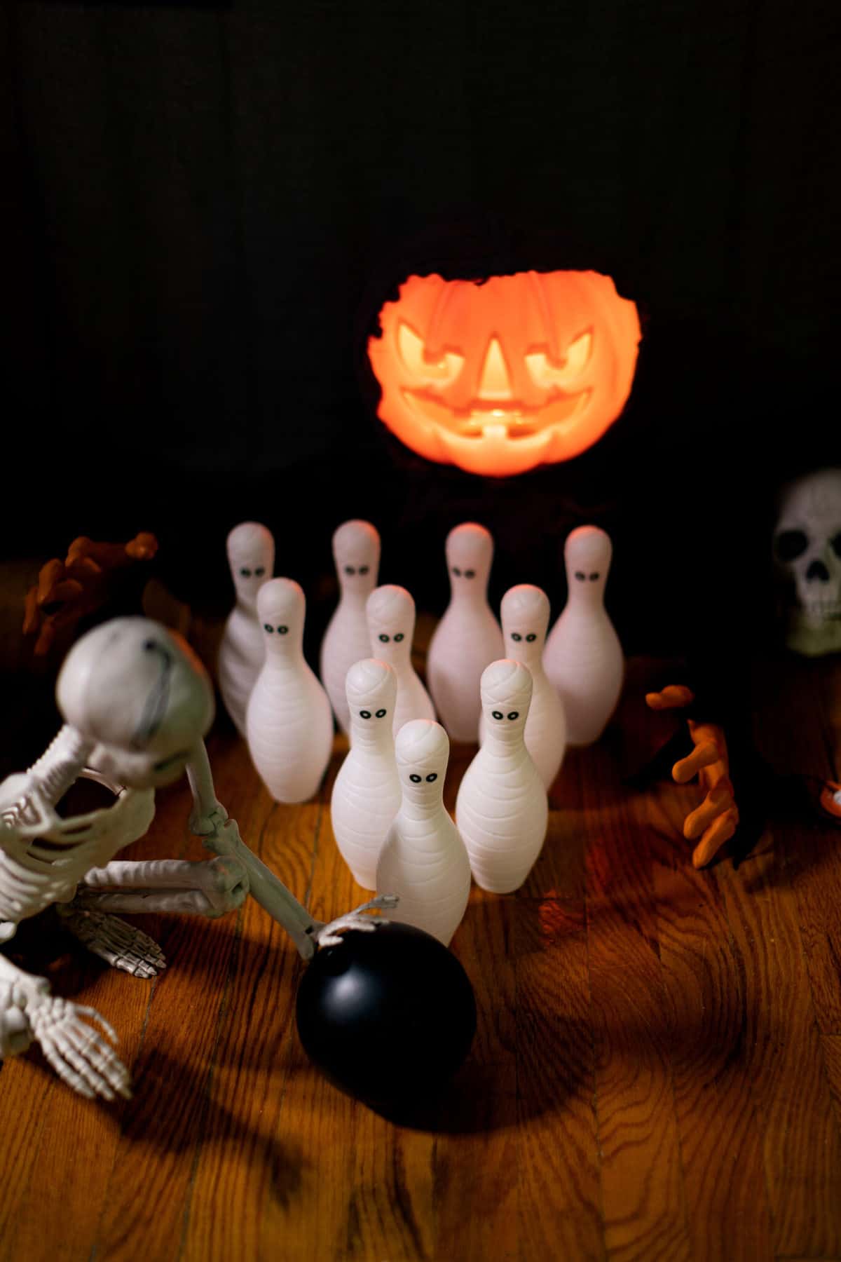 Mummified bowling pins next to a skeleton with a bowling ball.