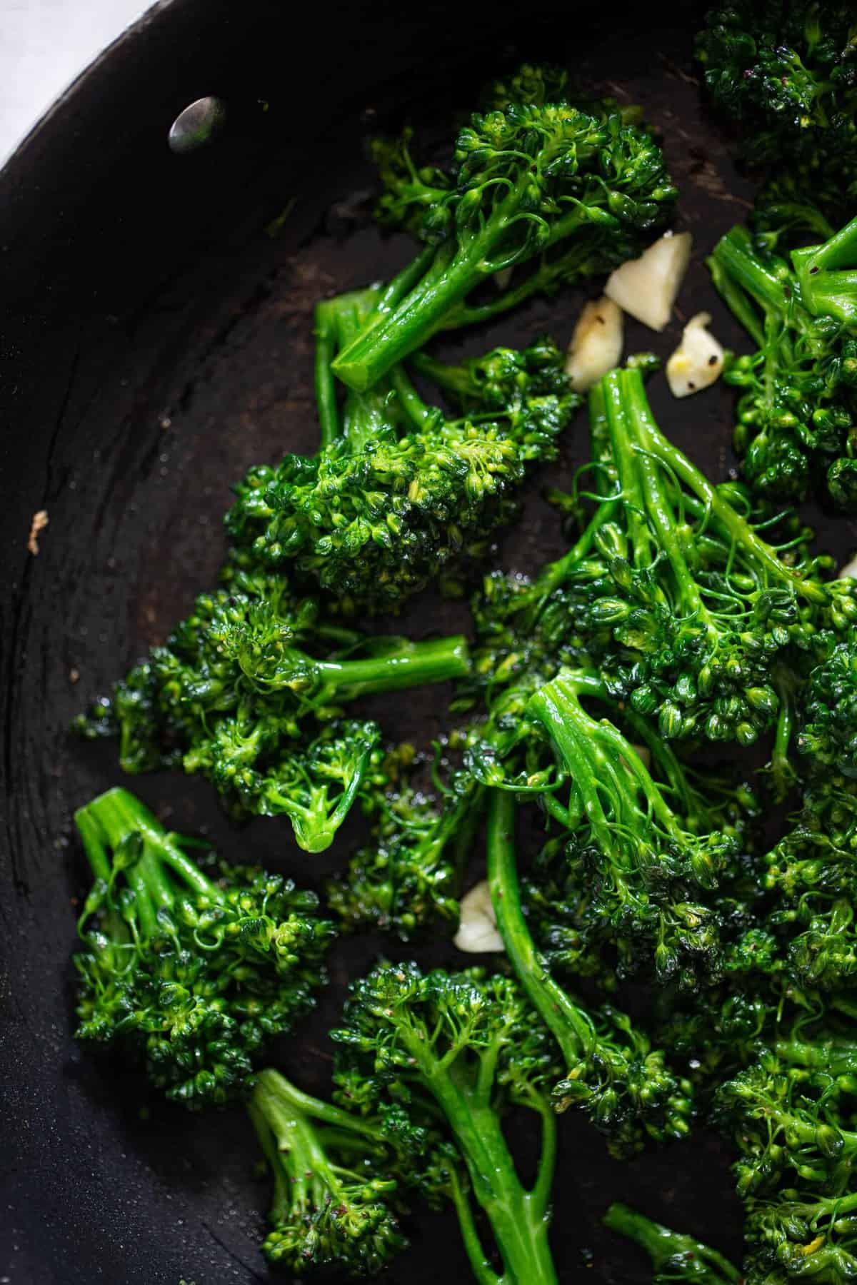 Broccolini and garlic in a skillet.