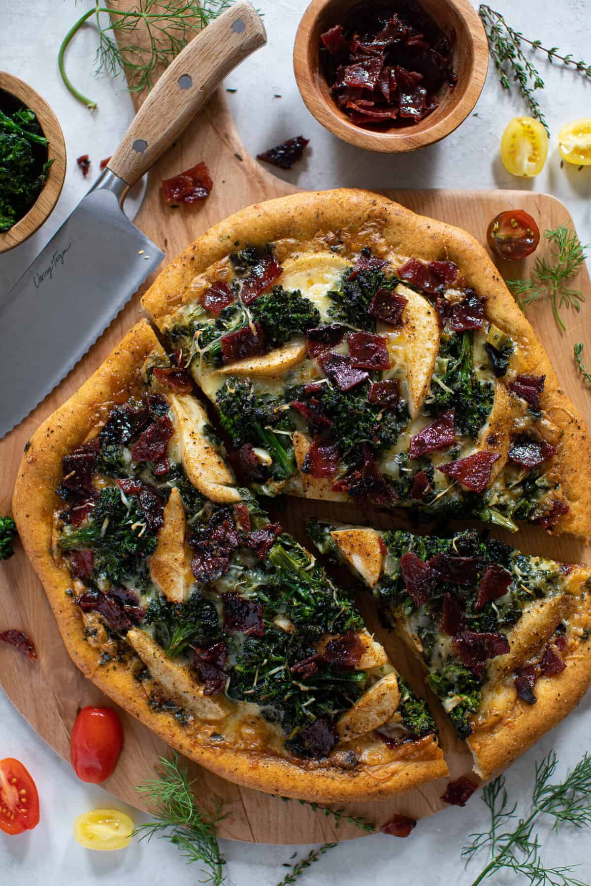 Partially-sliced Fall Harvest Pizza on a wooden cutting board.