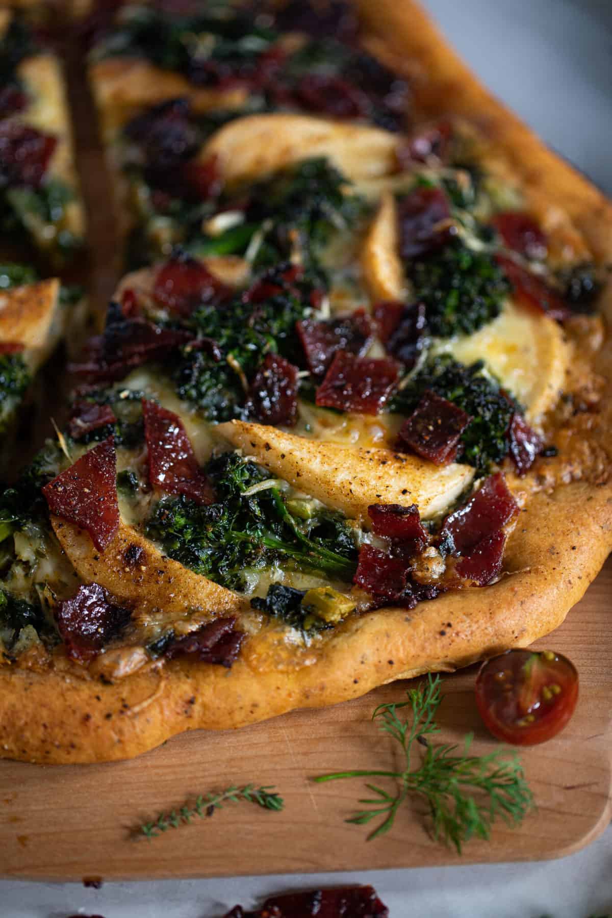 Apples, Candied Bacon, Broccolini, and Kale on a pizza.