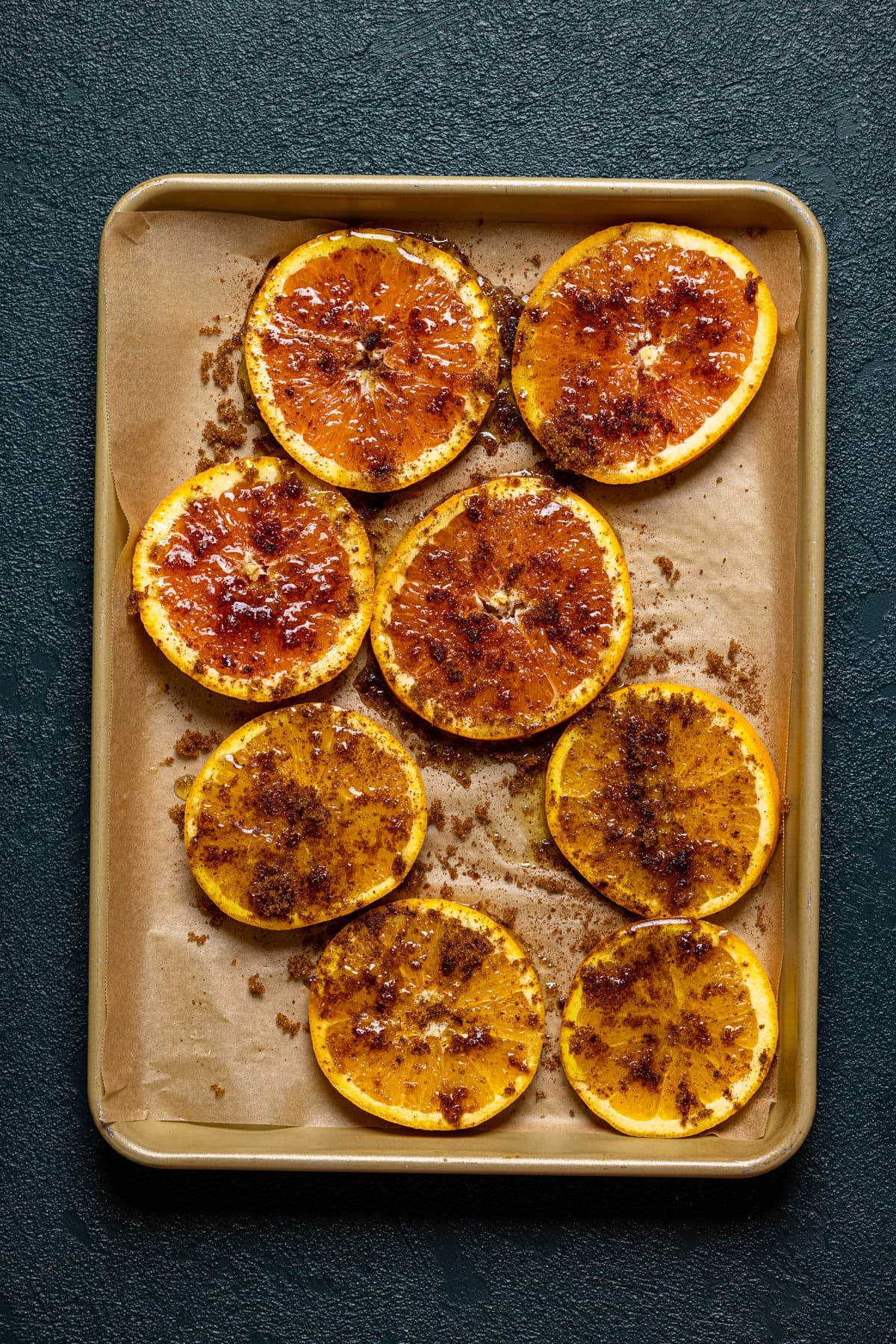 Seasoned orange slices on a baking sheet