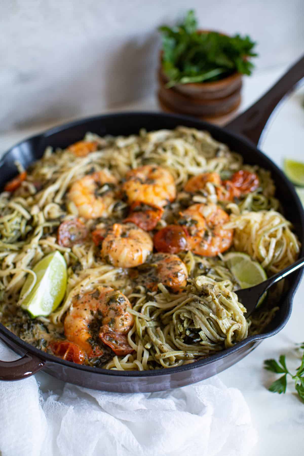 Fork in a skillet of Gluten-Free Coconut Lime Shrimp Pasta.