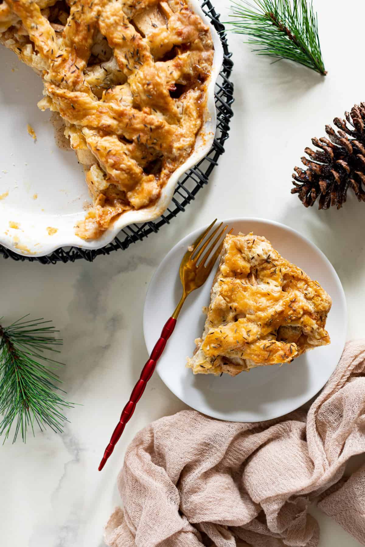 Slice of Apple Cheddar Thyme Pie on a small white plate.