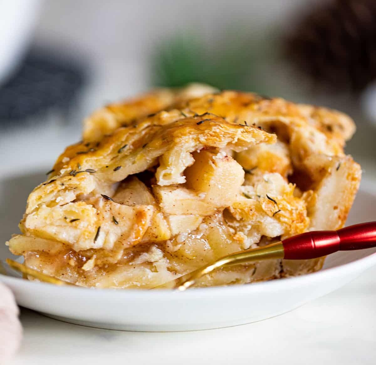 Slice of Apple Cheddar Thyme Pie on a plate