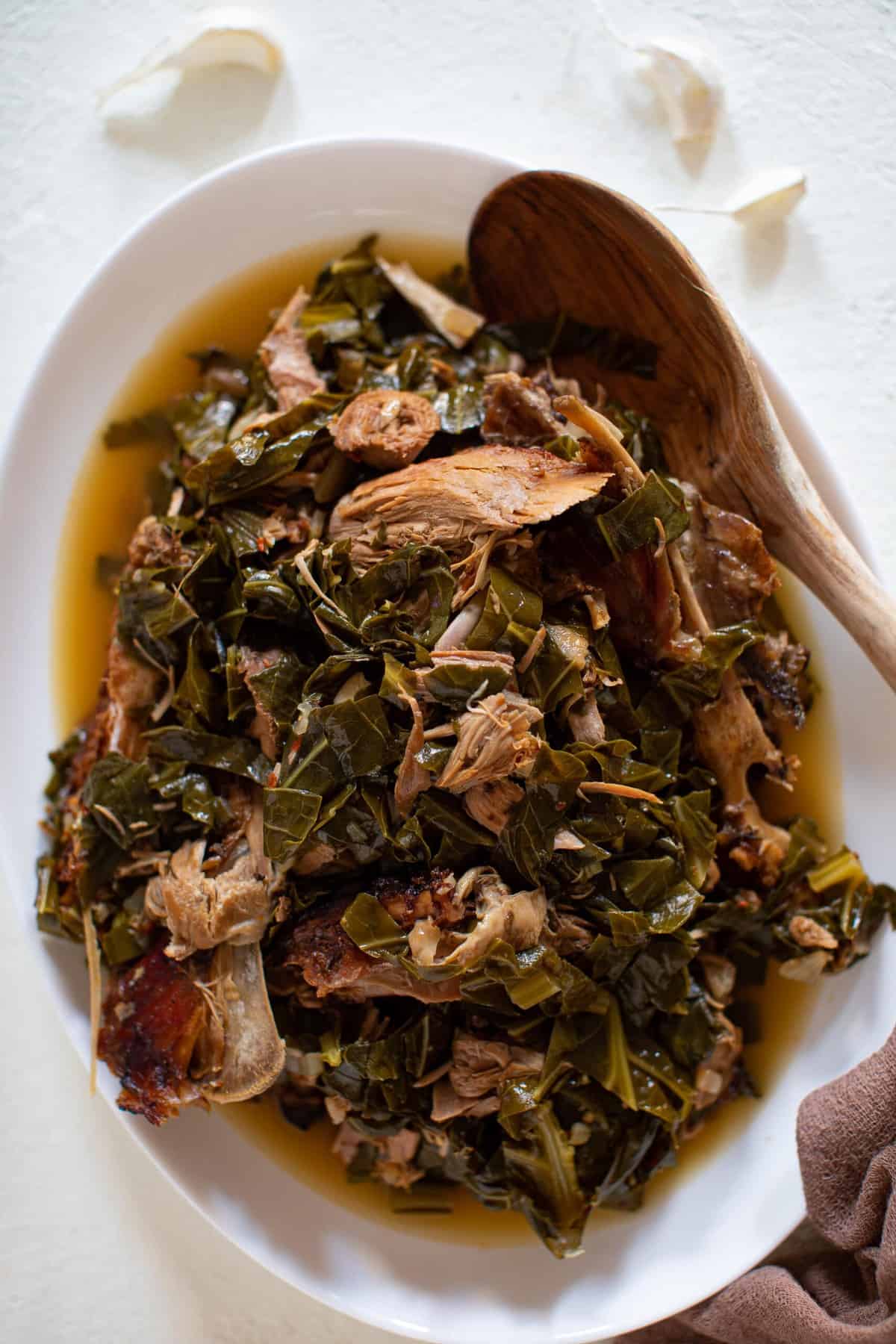 Wooden spoon in a large bowl of Leftover Turkey Southern Collard Greens