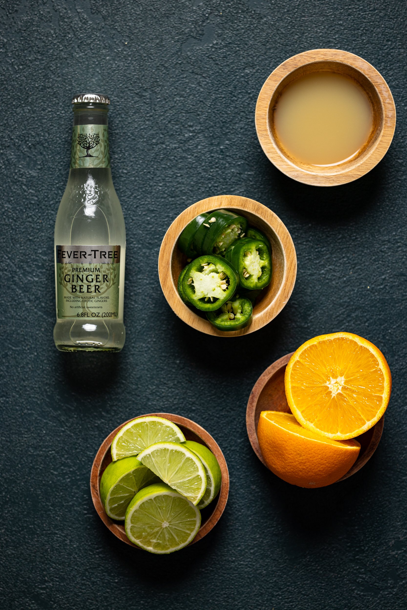 Ingredients for a Pineapple Jalapeño Lime Mocktail including jalapeno, orange, lime, and ginger beer