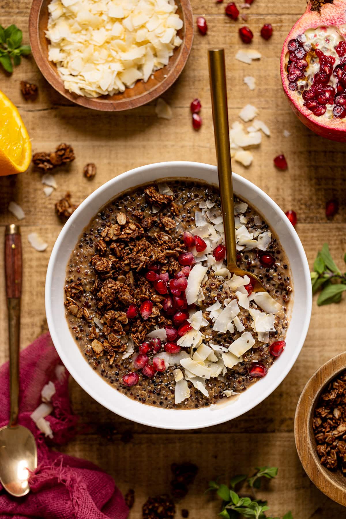 Spoon dipping into a Winter Quinoa Breakfast Bowl topped with pomegranate seeds