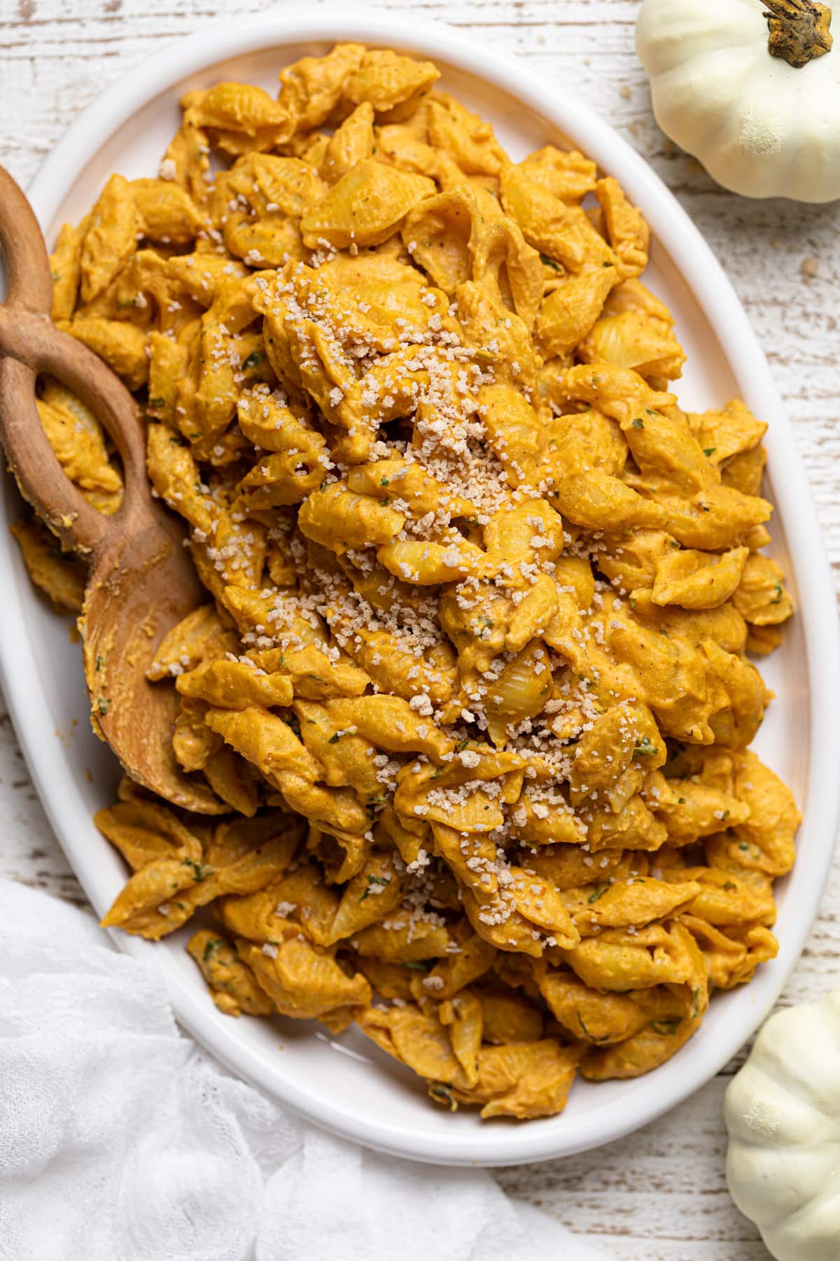 Wooden spoon in a serving platter of Vegan Pumpkin Mac and Cheese