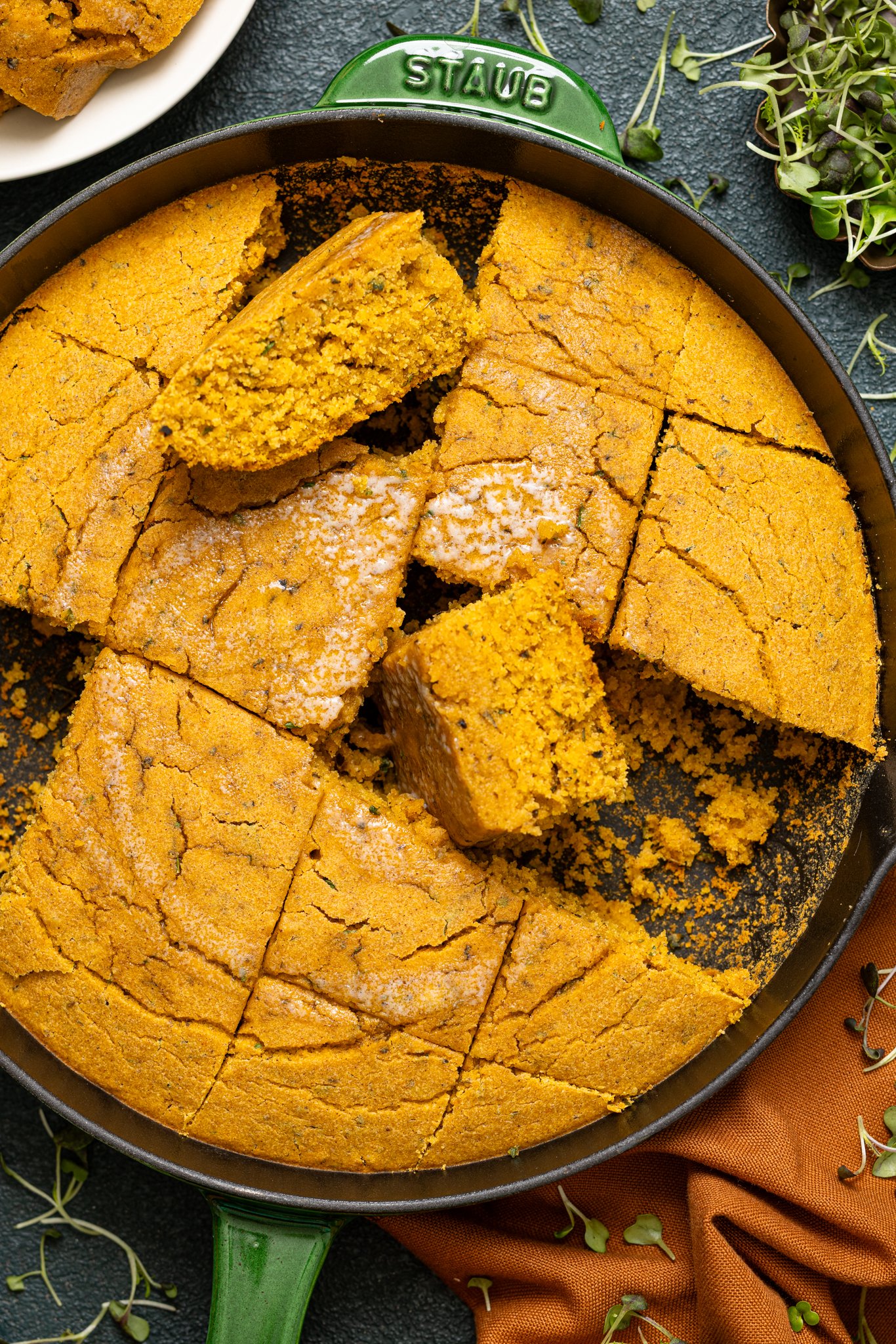 Vegan Sweet Potato Maple Herb Cornbread sliced in a skillet.